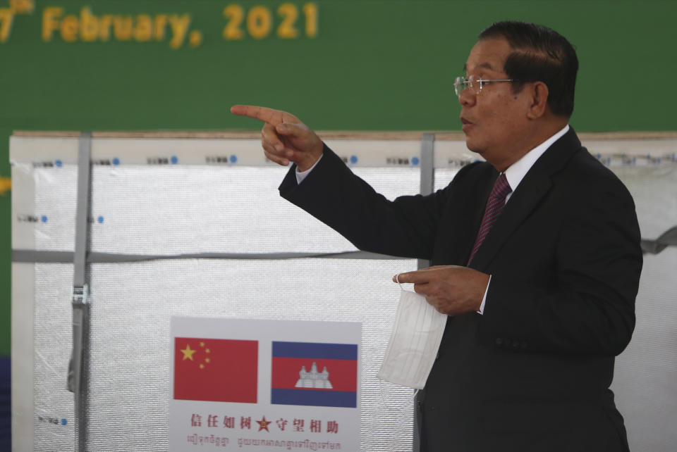 Cambodian Prime Minister Hun Sen gestures during a handover ceremony at Phnom Penh International Airport, in Phnom Penh, Cambodia, Sunday, Feb. 7, 2021. Cambodia on Sunday received its first shipment of COVID-19 vaccine, a donation of 600,000 doses from China, the country's biggest ally. Beijing has been making such donations to several Southeast Asian and African nations in what has been dubbed "vaccine diplomacy," aimed especially at poorer countries like Cambodia. (AP Photo/Heng Sinith)