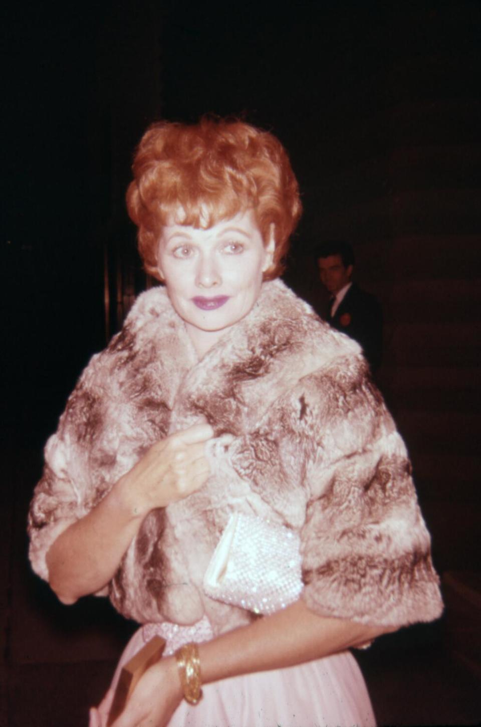 A red-haired woman in a fur shawl.