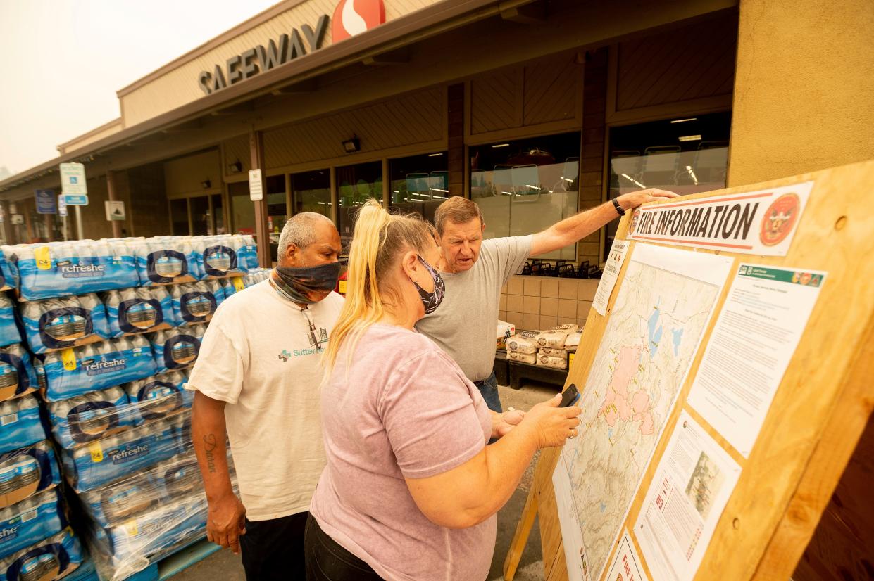 As new evacuation orders take effect for the Dixie Fire, residents examine a fire map in Quincy, Calif. on Sunday, July 25, 2021.