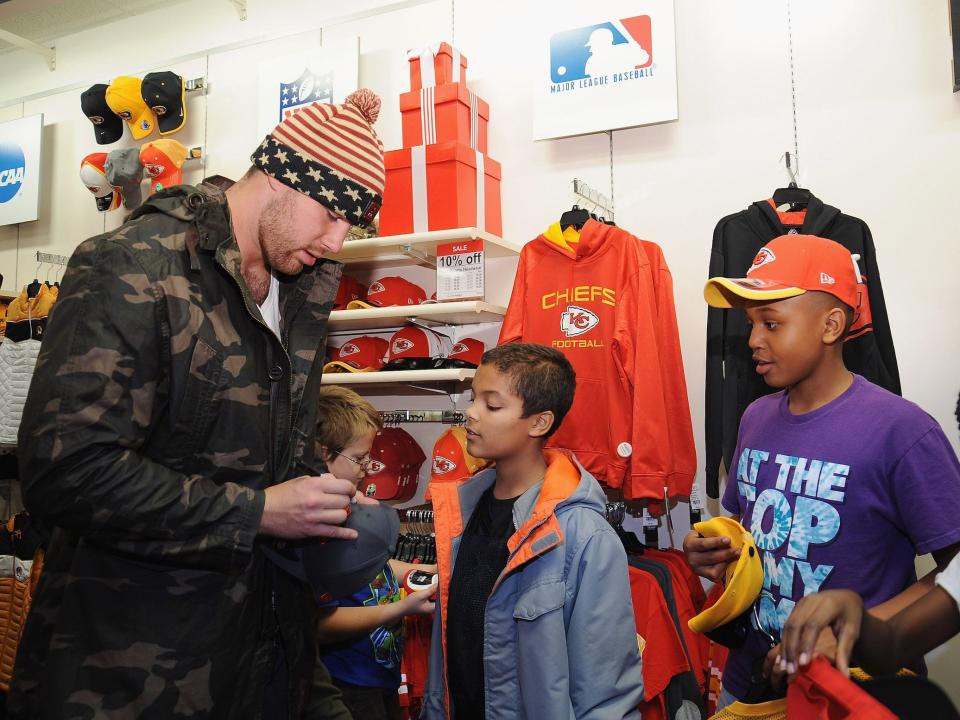 Travis Kelce signs merchandise at a JC Penney Holiday Event with the Boys & Girls Club of Greater Kansas City.