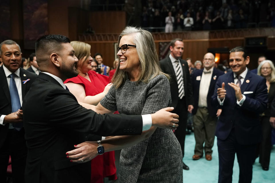 Arizona Democratic Gov. Katie Hobbs, right, gets a hug from Arizona House of Representatives Minority Leader Andrés Cano, D-Tucson, as Hobbs arrives to give the state of the state address at the Arizona Capitol in Phoenix, Monday, Jan. 9, 2023. (AP Photo/Ross D. Franklin)