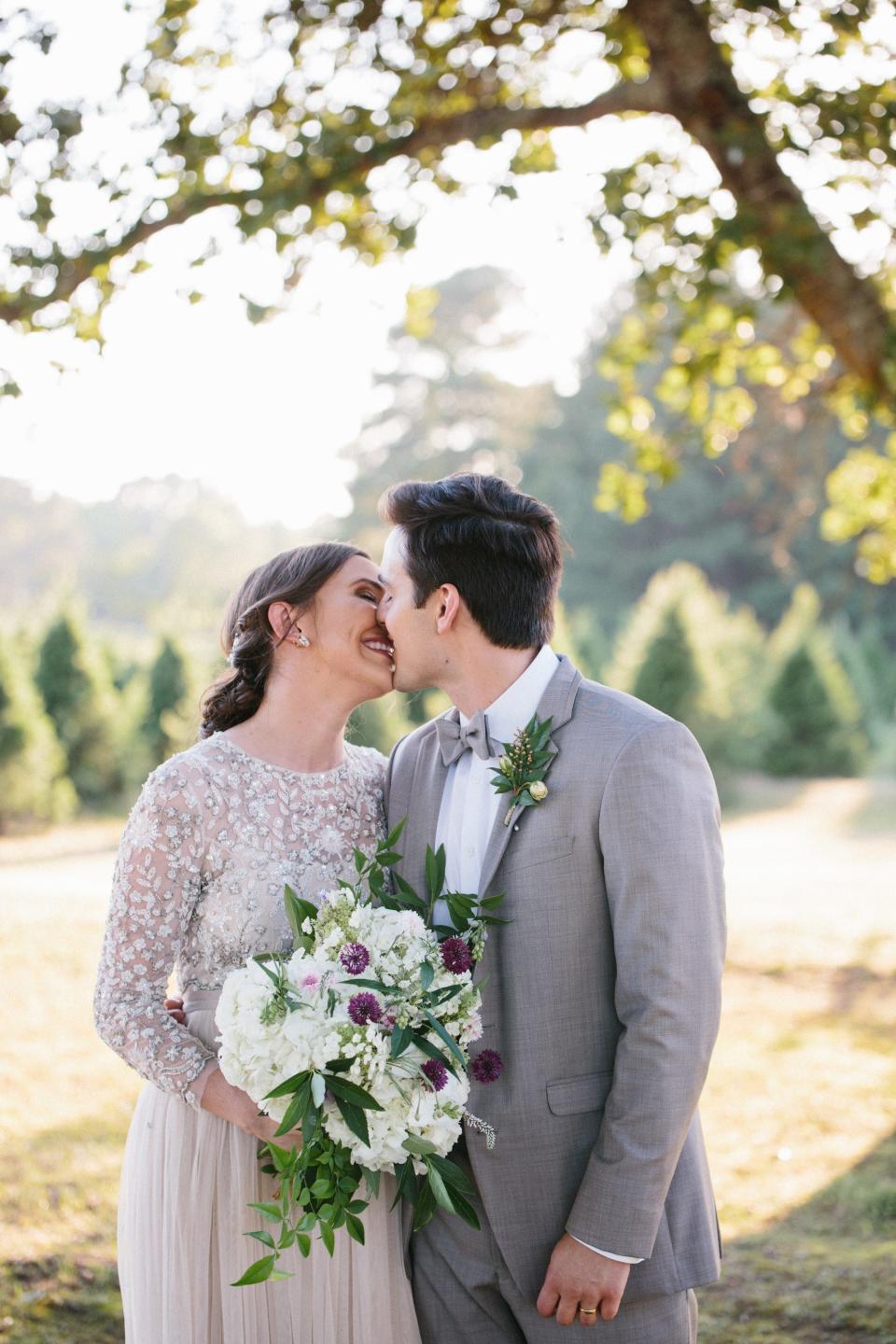 A bride and groom kiss on their wedding day.