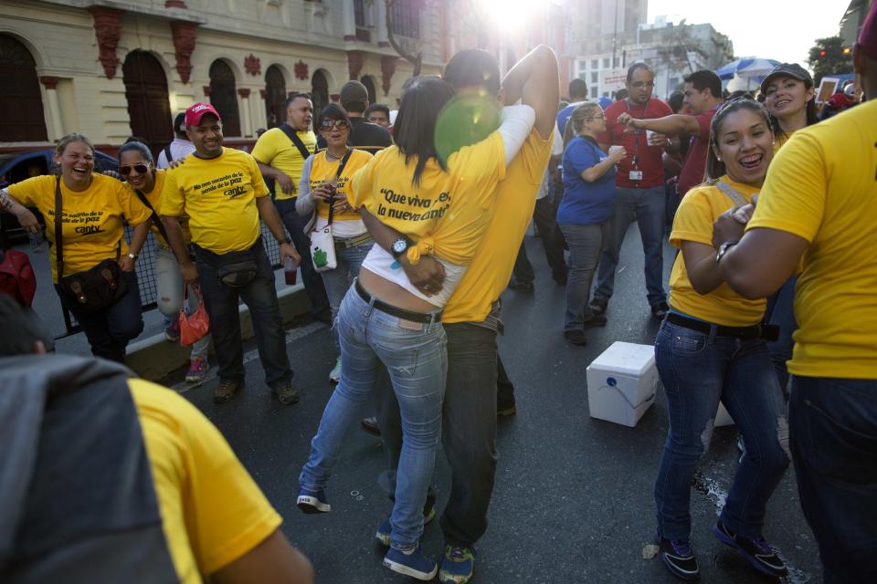 Workers from the National Telecommunications Company CANTV dance during a rally to show support for the government in Caracas, Venezuela, Tuesday, Feb. 25, 2014. (AP Photo/Rodrigo Abd)