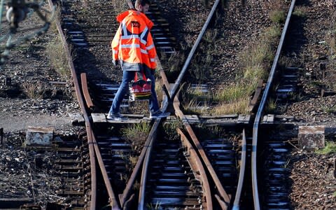 A railway worker walks on rails at Somain freight railway station - Credit: &nbsp;PASCAL ROSSIGNOL/REUTERS