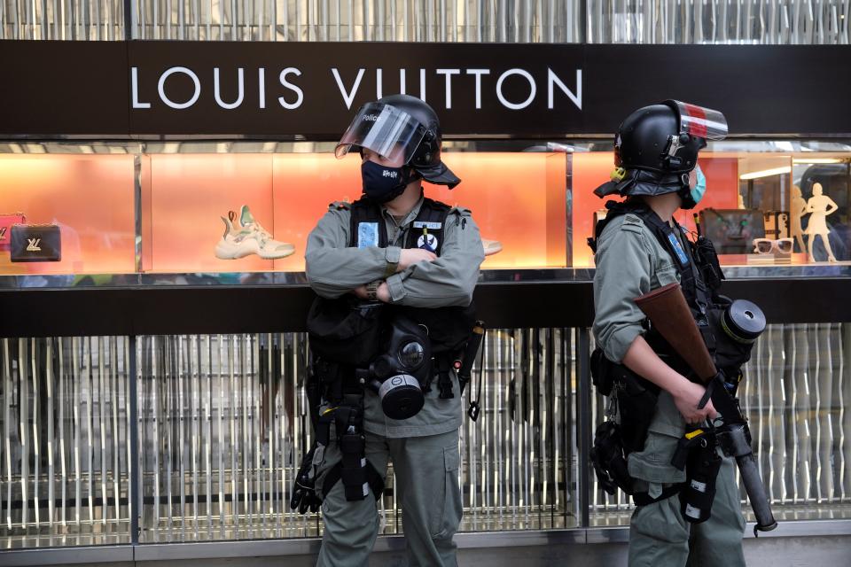 Image: Riot police stand guard outside a Louis Vuitton shop during a protest against Beijing's plans to impose national security legislation in Hong Kong (Tyrone Siu / Reuters)