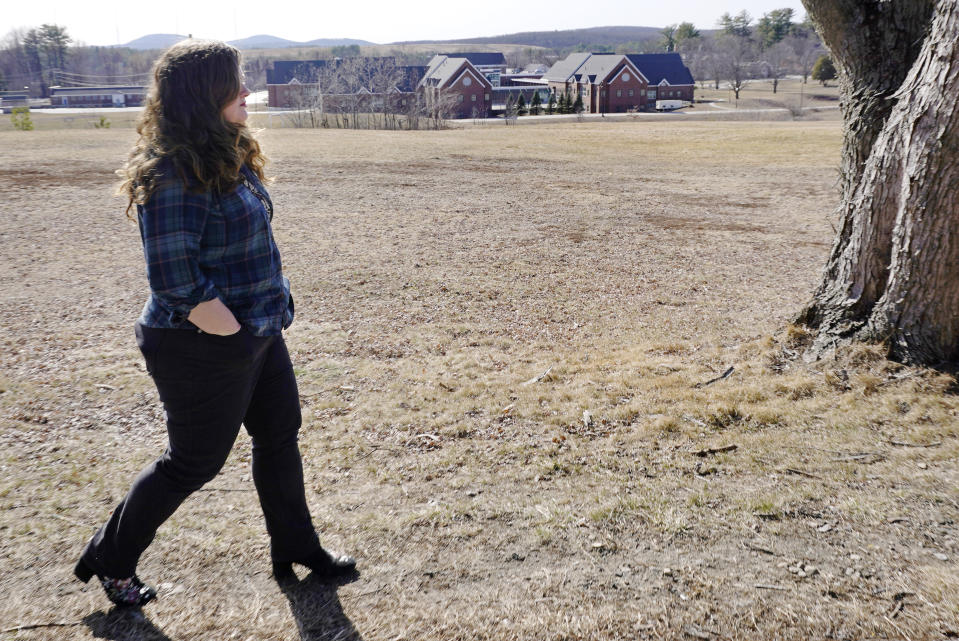 Mary Goddard walks back to her car after being photographed outside the Sununu Youth Development Center, at rear, Tuesday, March 23, 2021, in Manchester, N.H. Goddard, a former intern at New Hampshire’s youth detention center says a supervisor suggested she destroy her notes and lie about a teen’s sexual assault allegation. And though she reported the boy’s claim to state investigators and police, it wasn’t included in an annual report that state officials submitted to the federal government.(AP Photo/Charles Krupa)