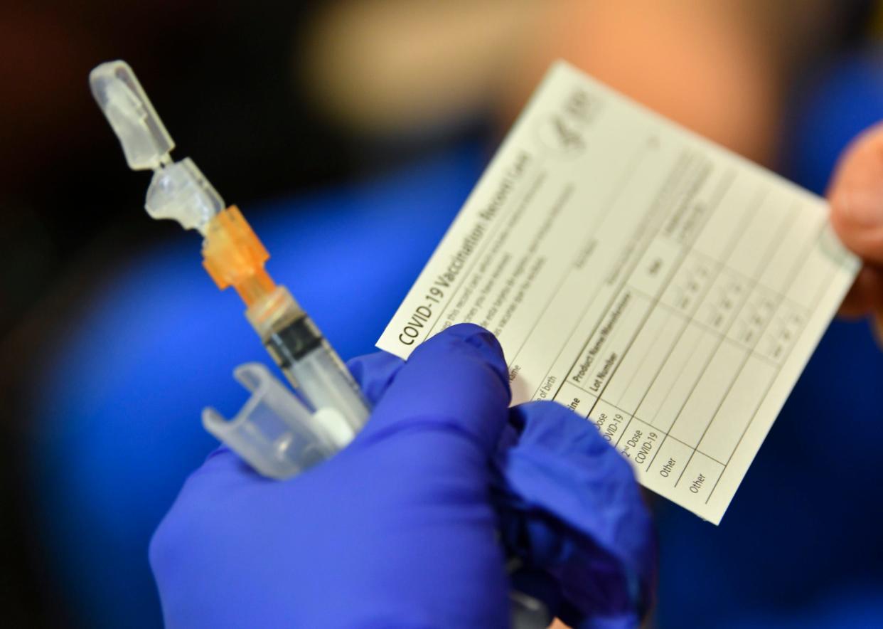 A nurse holds paperwork related to the COVID-19 vaccine Tuesday, Dec. 22, 2020, in the Community Living Center at the St. Cloud VA Health Care System.  