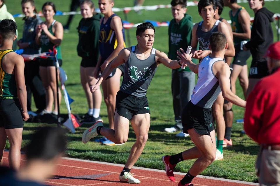 Pitman’s Ryan Dhillon hands the baton to teammate Julius Camacho in the boys 4x800 meter relay the Stanislaus County track meet at Hughson High School in Hughson, Calif., Friday, March 24, 2023. Pitman won the race with a time of 8:45.38.