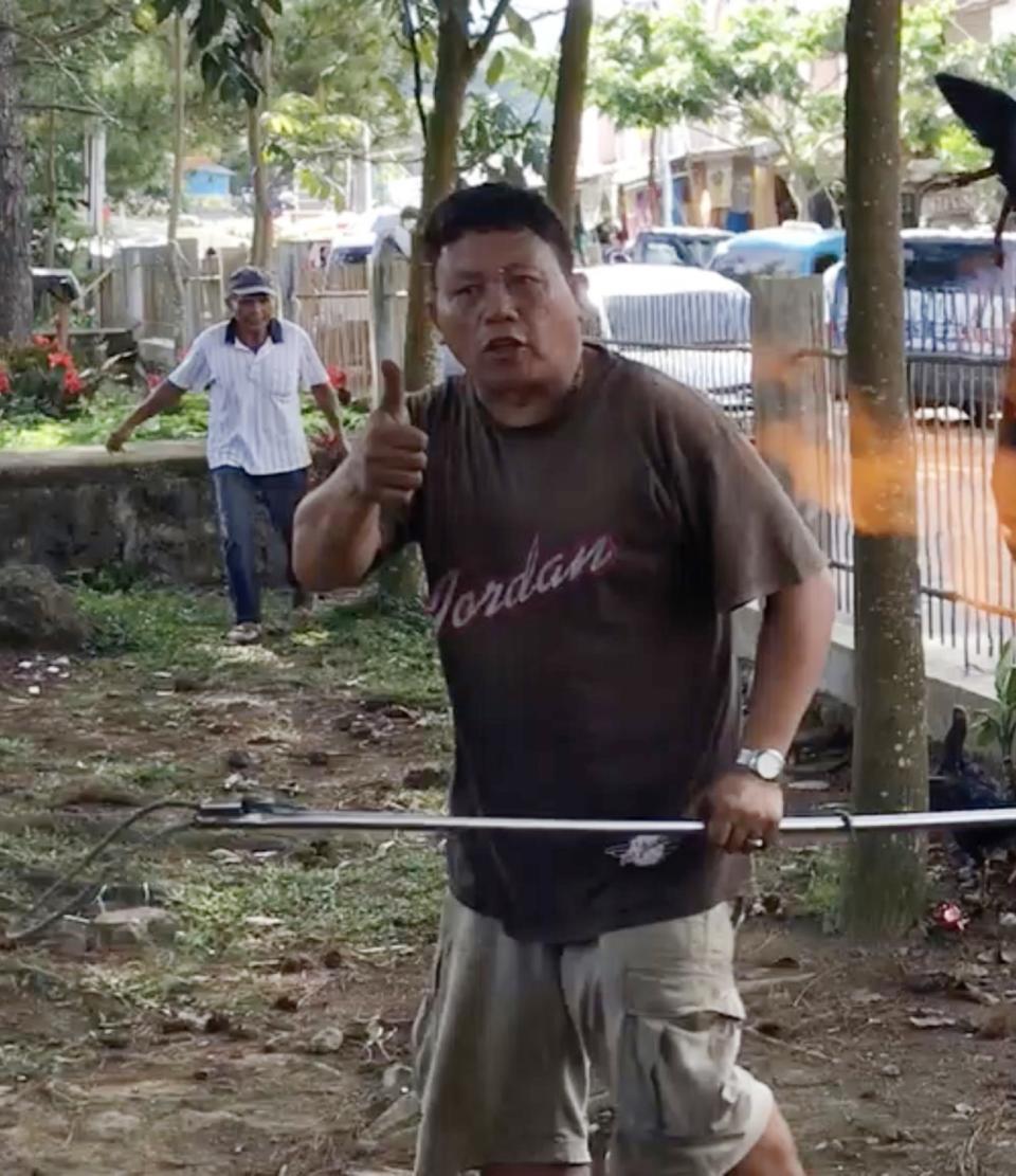 A still from the video shows a butcher flashing a thumbs up