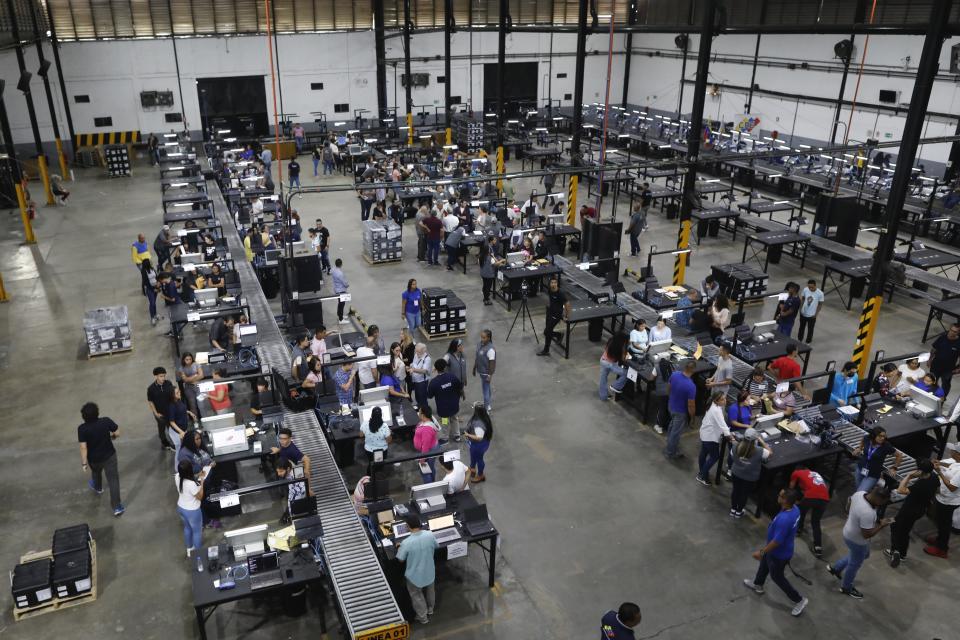 Miembros del Consejo Nacional Electoral prueban las máquinas de votación en Caracas, Venezuela, el 21 de julio de 2024. El país celebrará elecciones presidenciales el 28 de julio. (AP Foto/Cristian Hernandez)