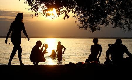 People enjoy warm summer day at a lake on the outskirts of Minsk, Belarus, August 10, 2017. REUTERS/Vasily Fedosenko/Files