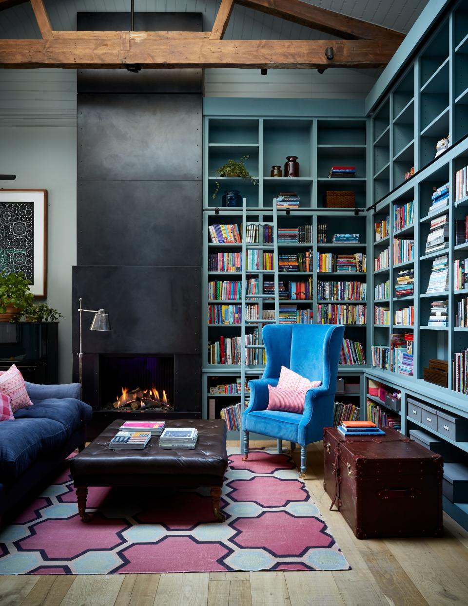 In another corner of the family room, an original wood beam and an antique-inspired armchair designed by bespoke furniture artisan Christopher Howe lend atmospheric age to contemporary details like the Soane floor lamp, custom Vanderhurd rug, and iron fireplace and hood. The custom joinery ties it all together with a coat of Pure & Original’s Blue Reef. (The walls are Farrow & Ball’s Light Blue for contrast.)