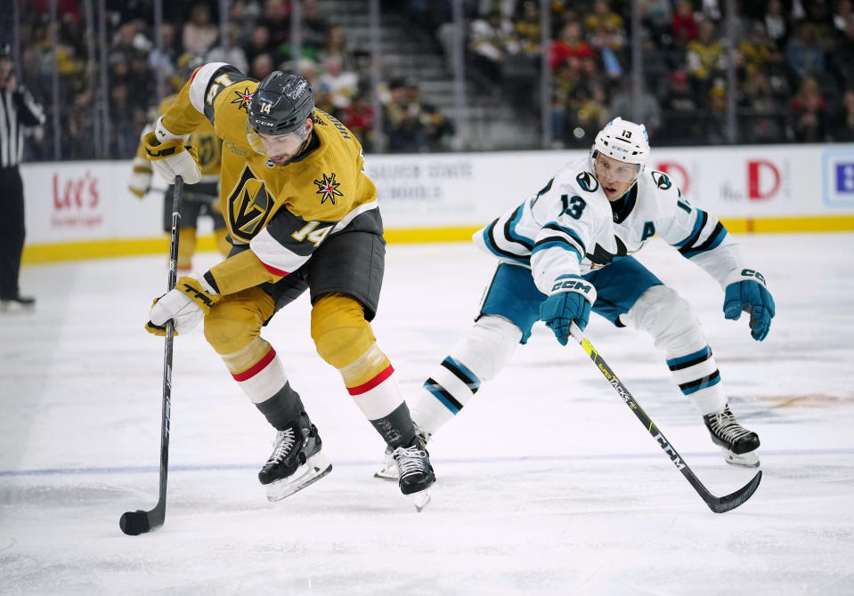 Vegas Golden Knights defenseman Nicolas Hague (14) works for the puck against San Jose Sharks center Nick Bonino (13) during the first period of an NHL hockey game Tuesday, Nov. 15, 2022, in Las Vegas. (AP Photo/Eric Jamison)