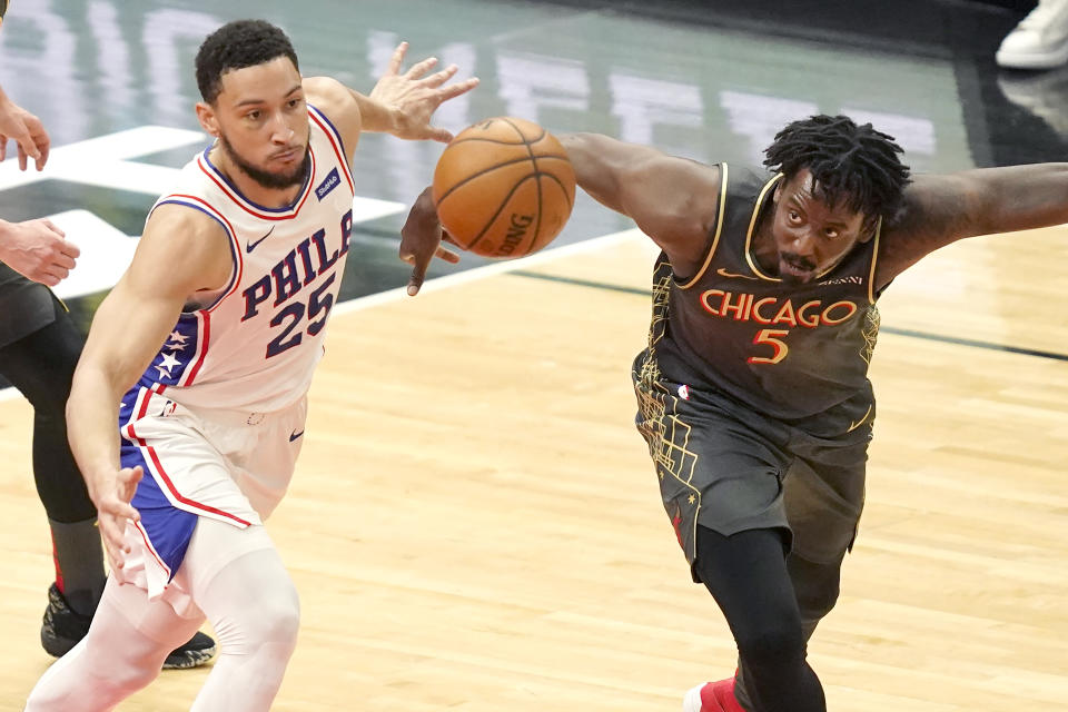 Philadelphia 76ers' Ben Simmons, left, and Chicago Bulls' Al-Farouq Aminu, right, keep their eyes on a loose ball during the first half of an NBA basketball game Monday, May 3, 2021, in Chicago. (AP Photo/Charles Rex Arbogast)