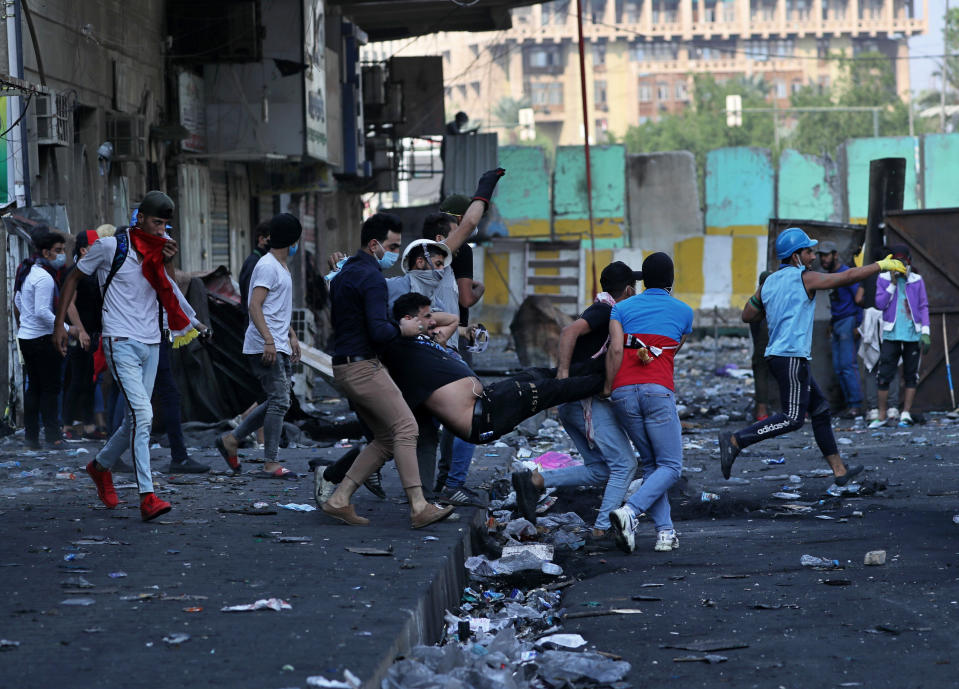 An injured protester is rushed to a hospital during clashes between Iraqi security forces and demonstrators, in Khilani Square, Baghdad, Iraq, Wednesday, Nov. 13, 2019. (AP Photo/Khalid Mohammed)