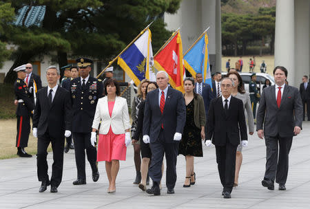 U.S. Vice President Mike Pence, center, and his wife Karen, center left, inspect hour guard upon their arrival at the National Cemetery in Seoul, South Korea, Sunday, April. 16, 2017. REUTERS/Ahn Young-joon/Pool