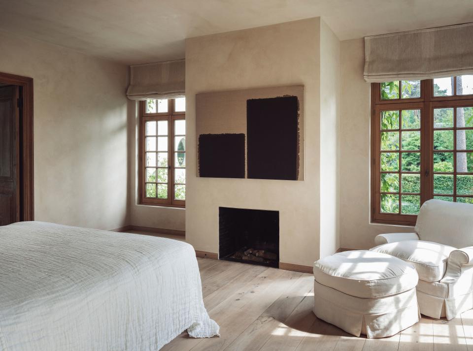 The master bedroom features abstract artwork by Korean artist Yun Hyong-keun and a neutral color palette.