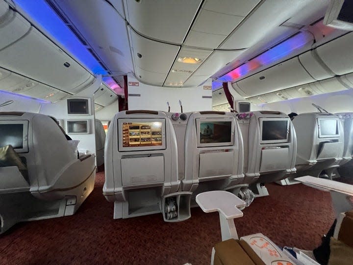 The entire business class cabin with TV screens.