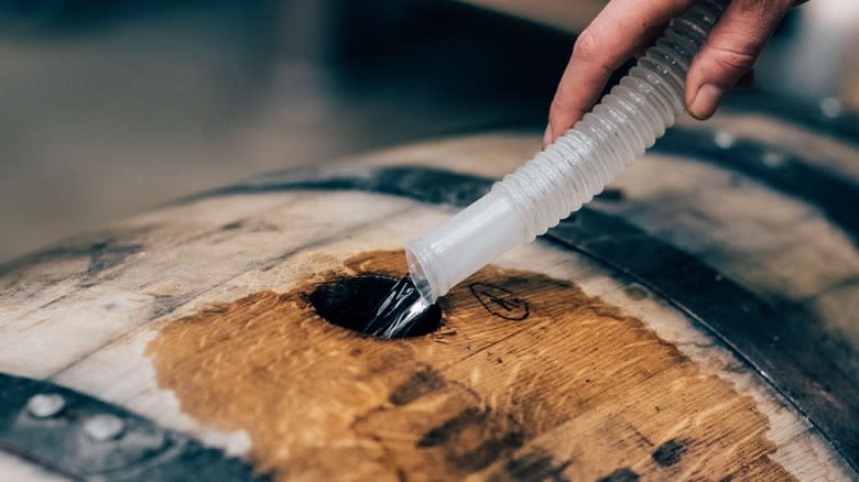 tube filling barrel with white whiskey