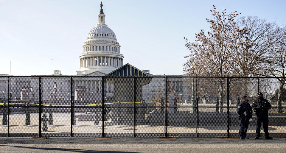 Capitol police officers stand outside of fencing that was installed around the exterior of the Capitol grounds, Thursday, Jan. 7, 2021 in Washington. The House and Senate certified the Democrat's electoral college win early Thursday after a violent throng of pro-Trump rioters spent hours Wednesday running rampant through the Capitol. A woman was fatally shot, windows were bashed and the mob forced shaken lawmakers and aides to flee the building, shielded by Capitol Police. (AP Photo/John Minchillo)