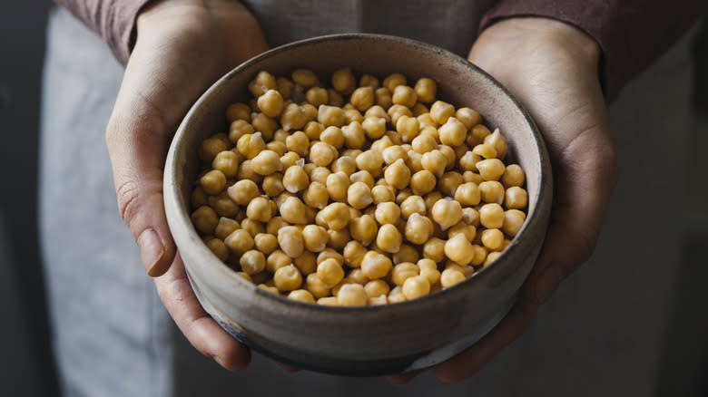 person holding bowl of chickpeas