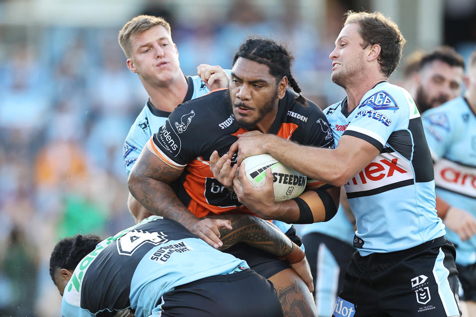 Pictured here, Tigers forward Thomas Mikaele being tackled during the round five NRL match against the Cronulla Sharks in 2022.