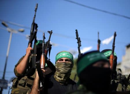 FILE PHOTO: Hamas militants hold weapons as they celebrate the release of Palestinian prisoner Mohammed al-Bashiti, who served 12 years in an Israeli jail after he was convicted of being a member of Hamas' armed wing, in Rafah in the southern Gaza Strip July 25, 2016. REUTERS/Ibraheem Abu Mustafa/File Photo
