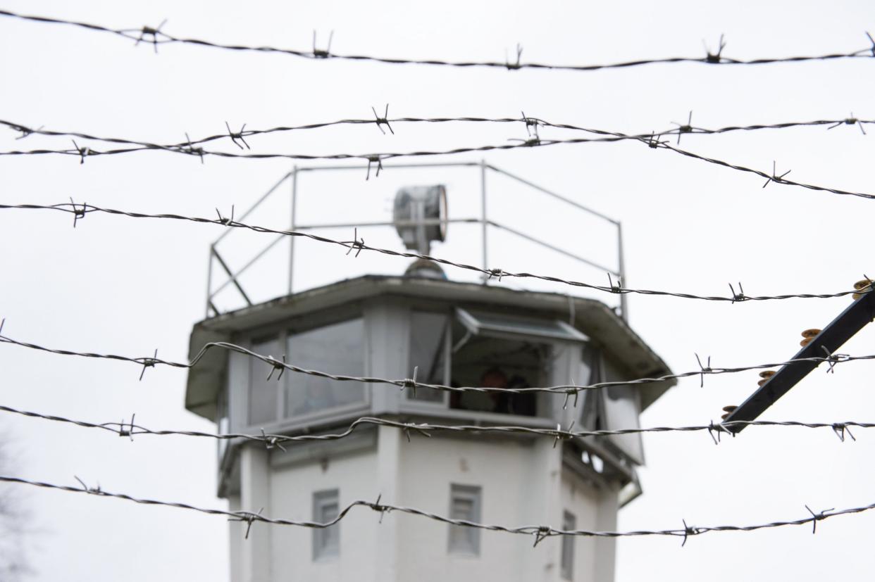 A former GDR border watchtower behind the barbed fence at former East German - West German borderline: EPA