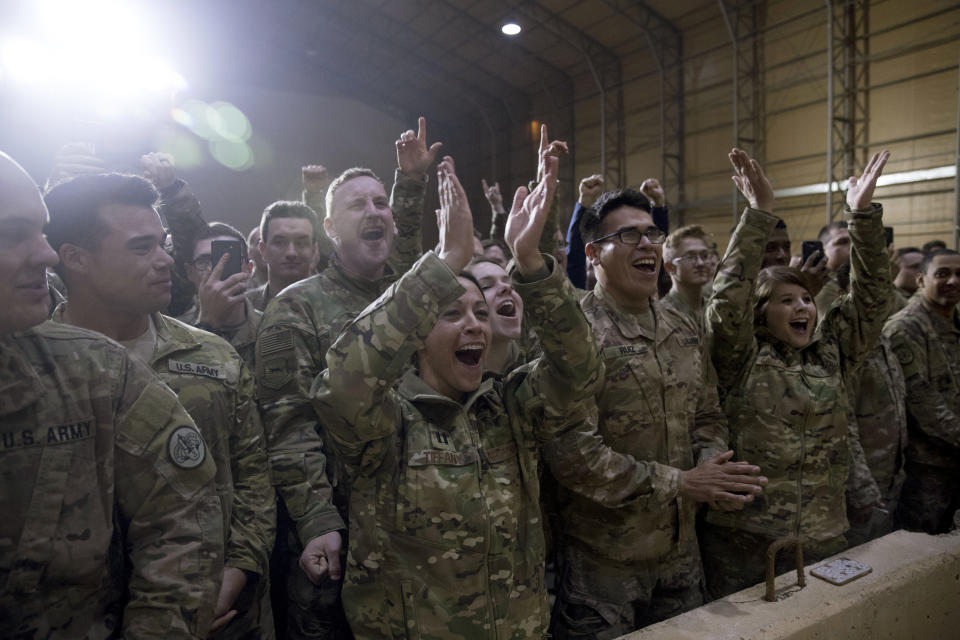 FILE - In this Dec. 26, 2018, file photo, members of the military cheer as President Donald Trump speaks at a hangar rally at Al Asad Air Base, Iraq. President Donald Trump tells troops serving in Iraq that he got them their first pay raise in 10 years and it’s a big one. No, and not exactly. (AP Photo/Andrew Harnik, File)
