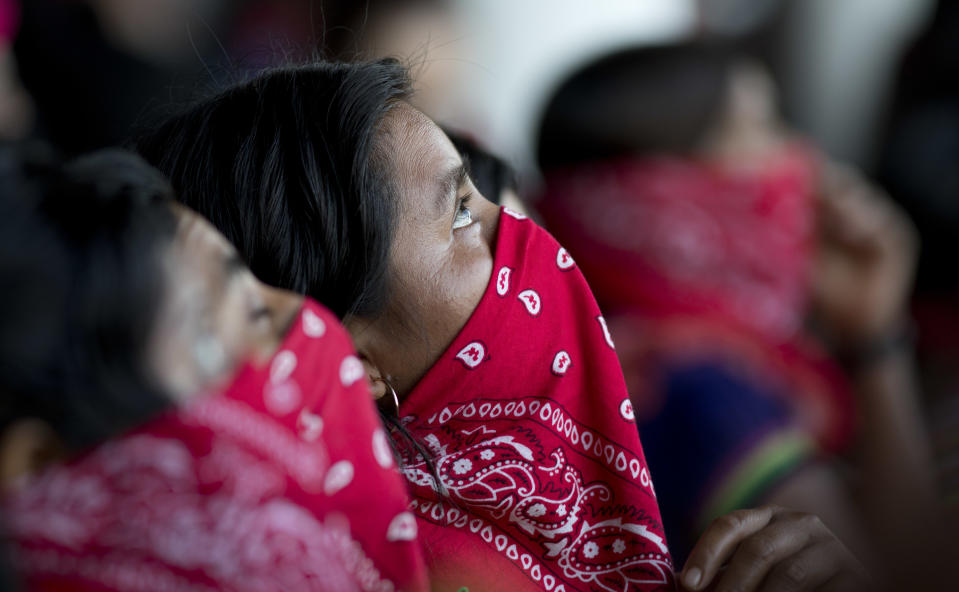 Members of the Zapatista National Liberation Army, EZLN, observe the arrival of more rebels during an event marking the 25th anniversary of the Zapatista uprising, in La Realidad, Chiapas state, Mexico, Monday, Dec. 31, 2018. (AP Photo/Eduardo Verdugo)