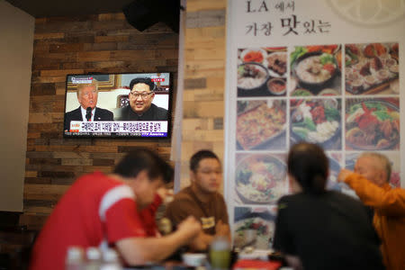 People look at a television screen with news of U.S. President Donald Trump's planned meeting of North Korea’s Kim Jong Un in Koreatown, Los Angeles, California, April 27, 2018. REUTERS/Lucy Nicholson