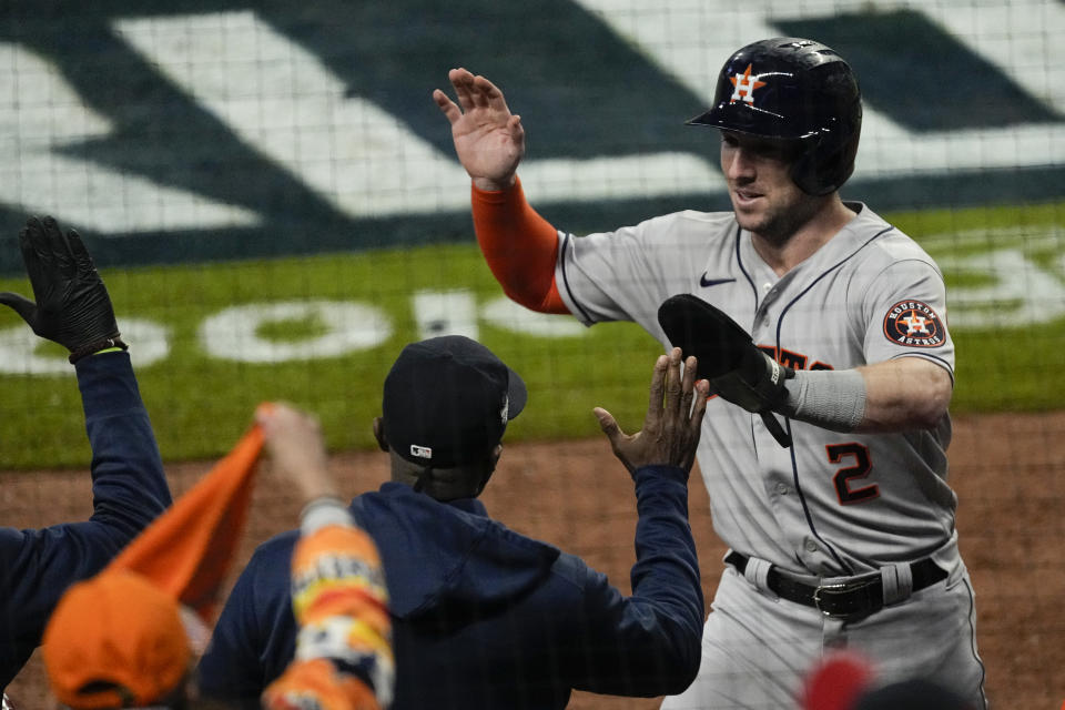 Houston Astros' Alex Bregman celebrates in the dugout after scoring on the double by Marwin Gonzalez during the fifth inning in Game 5 of baseball's World Series between the Houston Astros and the Atlanta Braves Sunday, Oct. 31, 2021, in Atlanta. (AP Photo/Ashley Landis)
