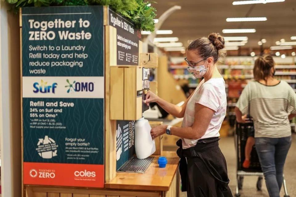 A Coles shopper refills her laundry detergent bottle in-store.