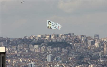 A helicopter carrying an election banner of Turkey's ruling AK Party (AKP) mayoral candidate and current mayor Melih Gokcek flies over Ankara March 18, 2014. REUTERS/Bulent Guler