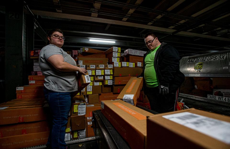 Katie King, left, and Preston Haggerman loaded packages onto a conveyor belt during a recent shift at the UPS Worldport facility in Louisville, Ky. King and Haggerman were hired on through the UPS Transitional Learning Center for people with physical or intellectual disabilities and are both working hard and earning their own money. Feb. 7, 2023