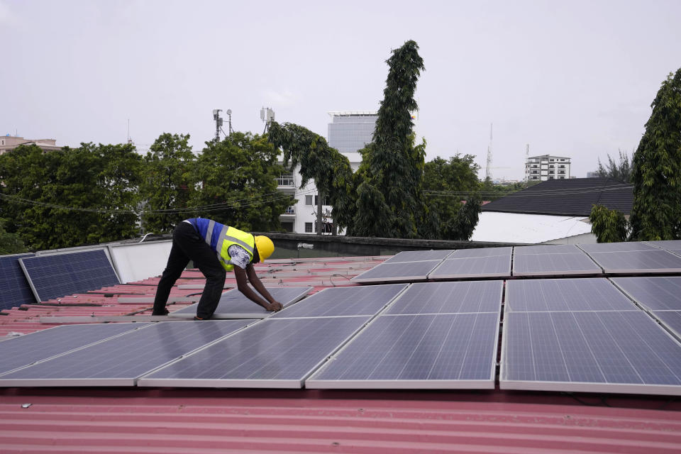 Oladapo Adekunle, an engineer with Rensource Energy, installs solar panels on a roof of a house in Lagos, Nigeria, Thursday, March 21, 2024. Funding for climate tech startups in Africa from the private sector is growing, but there's still a long way to go. (AP Photo/Sunday Alamba)