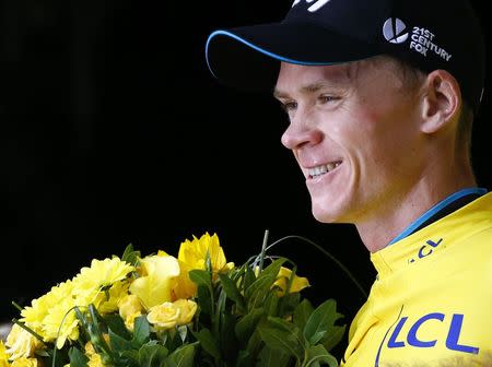Team Sky rider Chris Froome of Britain wears the race leader's yellow jersey on the podium after the 161-km (100 miles) 17th stage of the 102nd Tour de France cycling race from Digne-les-Bains to Pra Loup in the French Alps mountains, France, July 22, 2015. REUTERS/Stefano Rellandini