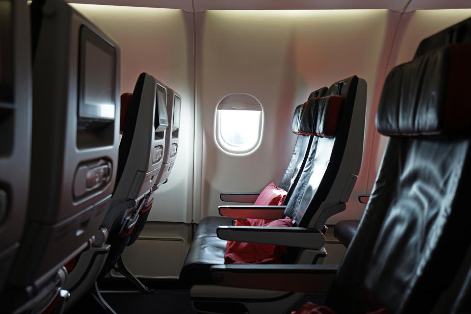 Airplane cabin with row of empty seats and window