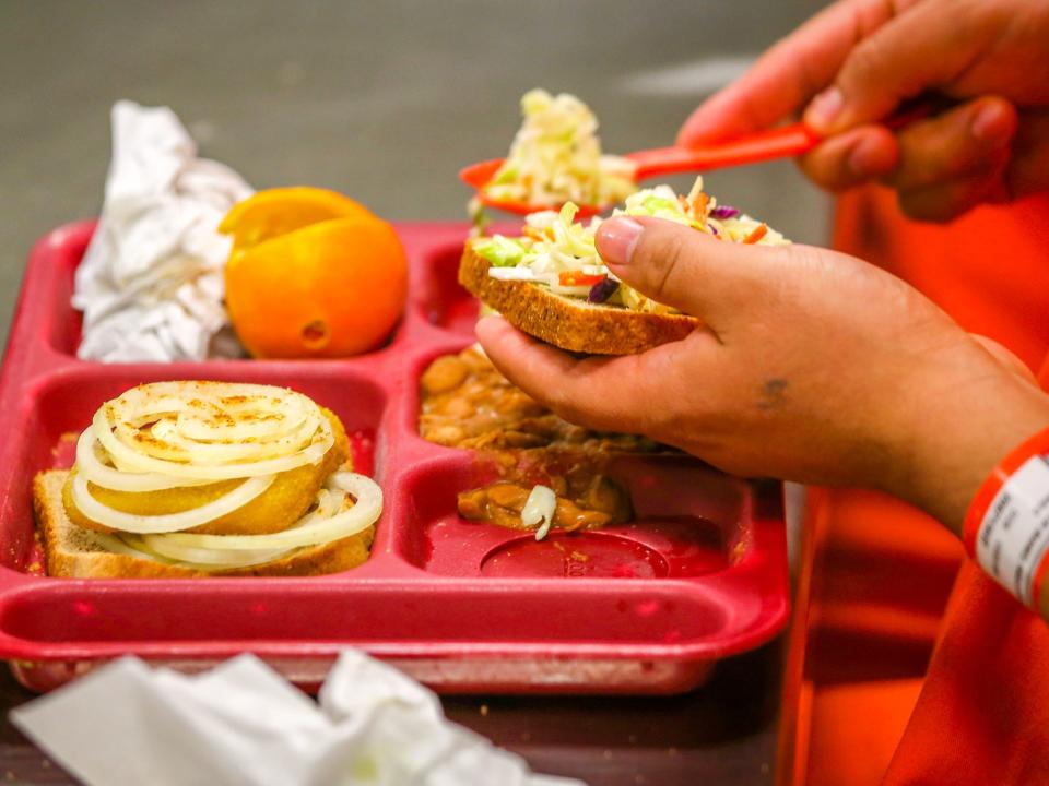 ADELANTO, CA - NOVEMBER 15: Immigrant detainees eat lunch, one of three meals a day, at the Adelanto Detention Facility on November 15, 2013 in Adelanto, California. The facility, the largest and newest Immigration and Customs Enforcement (ICE), detention center in California, houses an average of 1,100 immigrants in custody pending a decision in their immigration cases or awaiting deportation. The average stay for a detainee is 29 days. The facility is managed by the private GEO Group. ICE detains an average of 33,000 undocumented immigrants in more than 400 facilities nationwide. (Photo by John Moore/Getty Images)