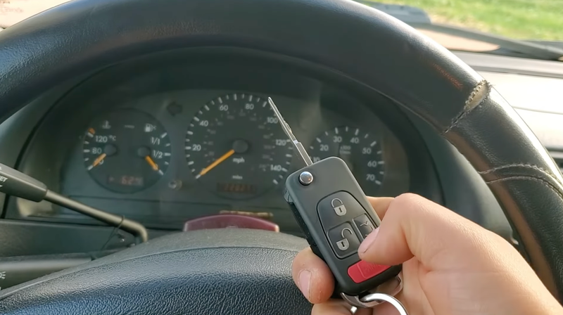 A switchblade Mercedes-Benz key in front of the instrument cluster.