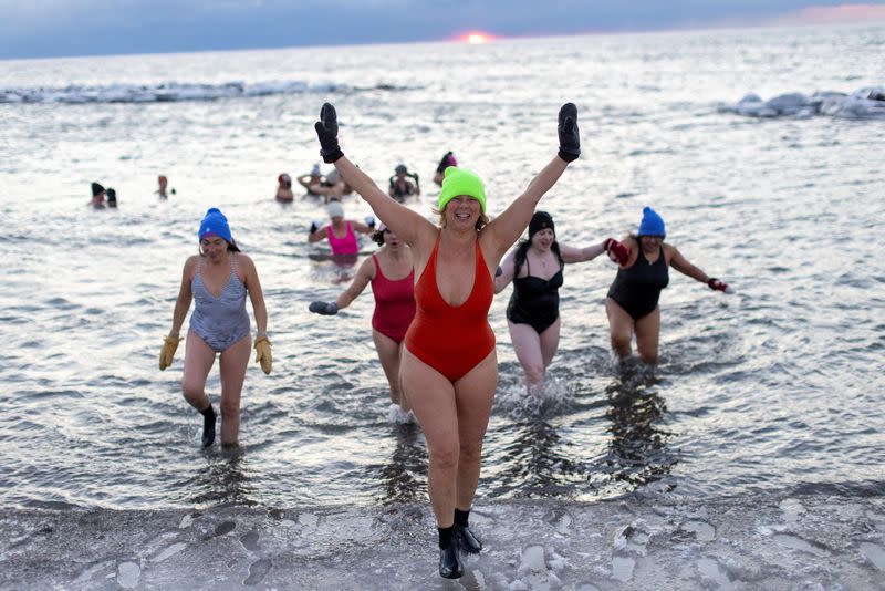 Women bathe in the chilly waters of Lake Ontario during freezing temperatures in Toronto