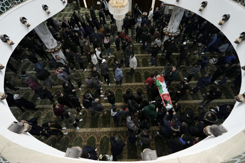 Palestinian mourners carry the body of Hamza al-Ashqar, 17, during his funeral in the Askar refugee camp near the West Bank city of Nablus, Tuesday, Feb. 7, 2023. The Palestinian Health Ministry says that Israeli troops killed the teenager, who died of a gunshot wound to the head during a raid. The Israeli military said its troops came under attack during a raid in Nablus, where soldiers fired at an armed Palestinian who shot at them. (AP Photo/Majdi Mohammed)