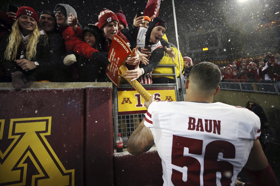 Wisconsin linebacker Zack Baun (56) holds out Paul Bunyan's Axe for fans to touch after Wisconsin beat Minnesota 38-17 in an NCAA college football game Saturday, Nov. 30, 2019, in Minneapolis. (AP Photo/Stacy Bengs)