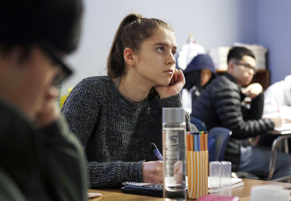 Senior Hazel Ostrowski attends her first period AP statistics class at Franklin High School Wednesday, Dec. 12, 2018, in Seattle. High school students are getting more sleep in Seattle, according to a study on later school start times. Ostrowski was among a group at Franklin and another Seattle high school who wore activity monitors to discover whether a later start to the school day would help them get more sleep. It did, adding 34 minutes of slumber a night, and they reported less daytime sleepiness and grades improved. (AP Photo/Elaine Thompson)