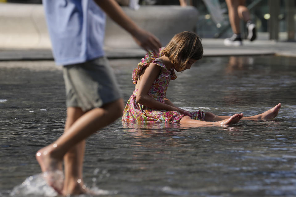 Children cool off in a public fountain in Milan, Italy, Saturday, July 15, 2023. Temperatures reached up to 42 degrees Celsius in some parts of the country, amid a heat wave that continues to grip southern Europe. (AP Photo/Luca Bruno)