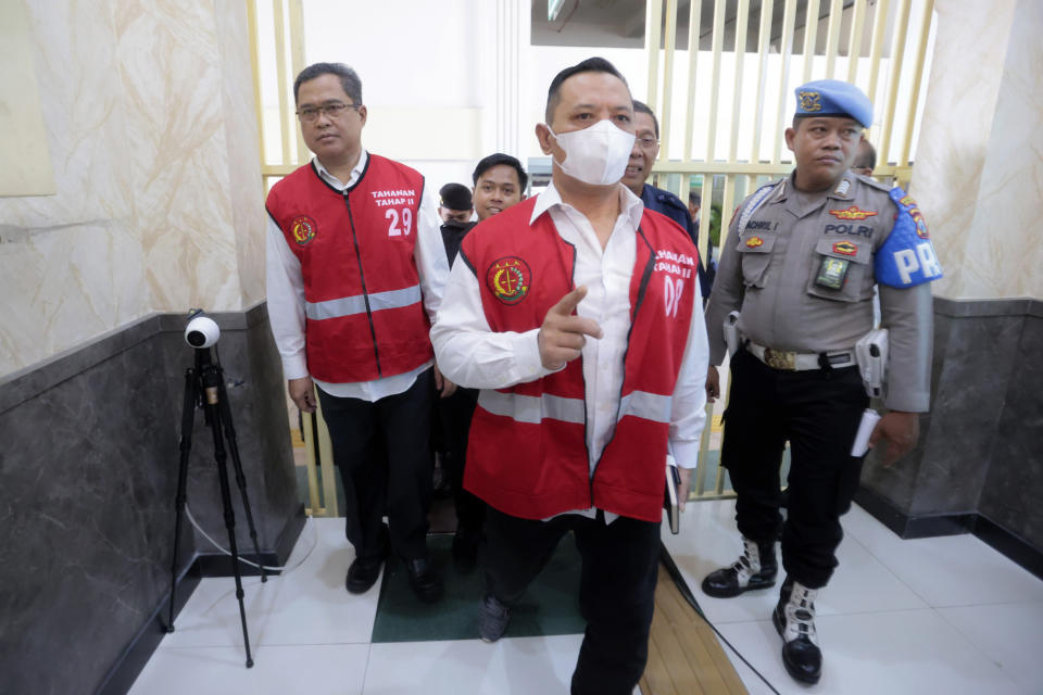 Arema FC Organizing Committee chair Abdul Haris, left, the club's security chief Suko Sutrisno, center, walk to the courtroom to attend their sentencing hearing at a district court in Surabaya, East Java, Indonesia, Thursday, March 9, 2023. The soccer club organizer and its chief of security were jailed by the Indonesian court on Thursday on charges of negligence leading to the deaths of 135 people when police fired tear gas inside a stadium last October, setting off a panicked run for the exits. (AP Photo/Trisnadi)