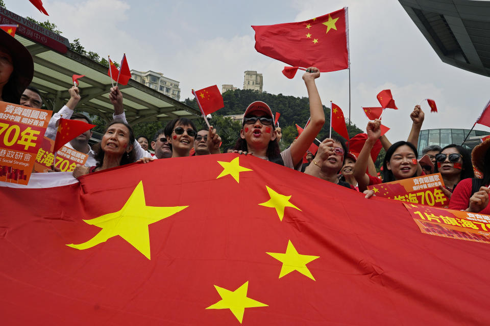 Pro-China supporters wave Chinese national flag at the Peak in Hong Kong Sunday, Sept. 29, 2019. Hundreds of pro-Beijing supporters sang Chinese national anthem and waved red flags ahead of China's National Day, in a counter to months-long pro-democracy protests viewed as a challenge to Beijing's rule. (AP Photo/Vincent Yu)