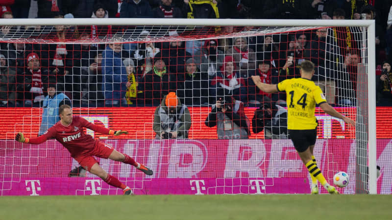 Dortmund's Niclas Fuellkrug (R) scores a penalty against Cologne goalkeeper Marvin Schwaebe during the German Bundesliga soccer match between 1. FC Cologne and Borussia Dortmund at the RheinEnergieStadion. Rolf Vennenbernd/dpa