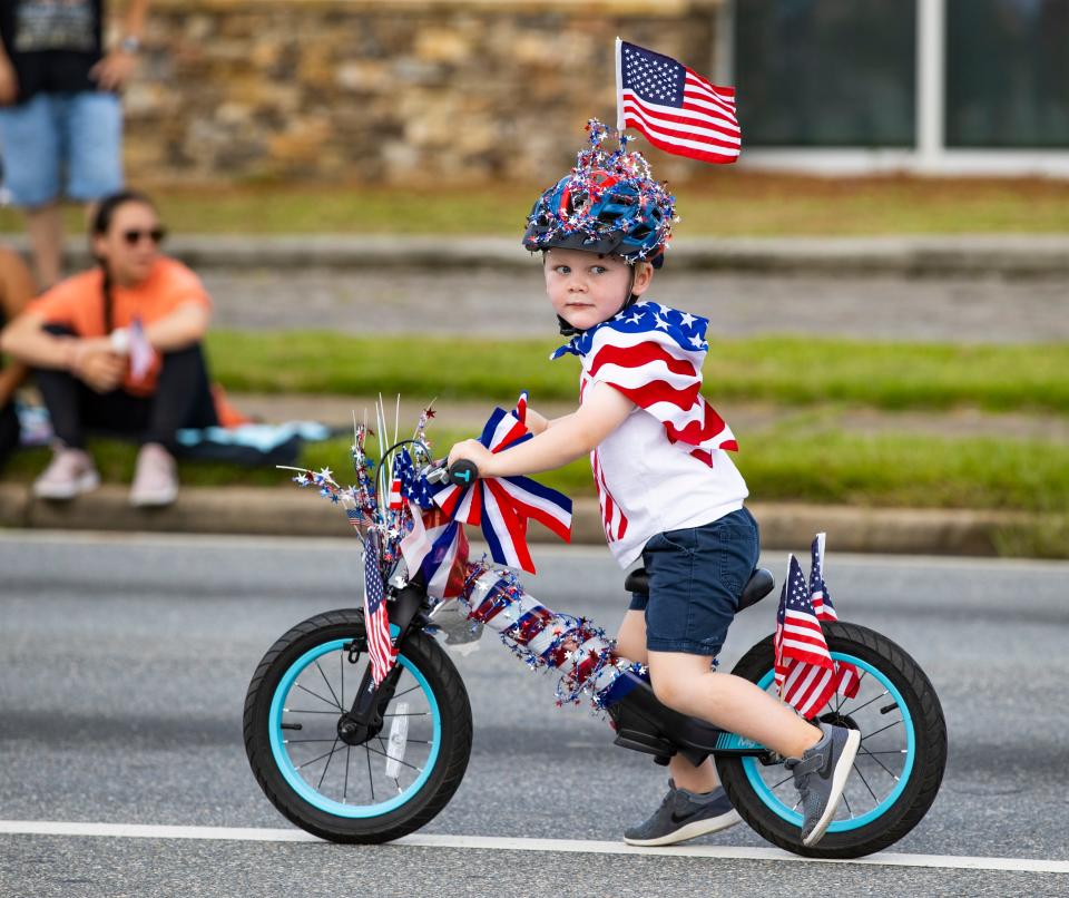 A member of the bicycle riders travels down Highway 77 during this year's Lynn Haven Fourth of July parade. The Bay County Commission has delayed several bicycle lane projects because of the rising cost of materials.