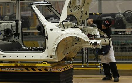 An employee works on a 2013 Mini at BMW's plant in Oxford, southern England November 18, 2013. REUTERS/Suzanne Plunkett